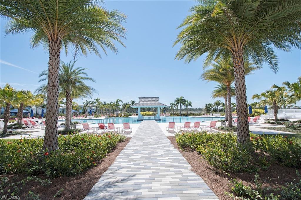 8829 Paradera Court Naples, FL 34112 - Photo 27 of 31 a view of a lake with a yard and palm trees