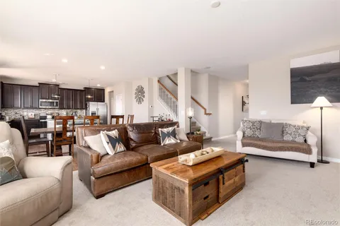 a living room with furniture and a view of kitchen