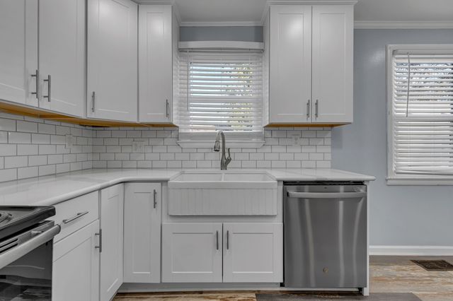 a kitchen with white cabinets and a sink