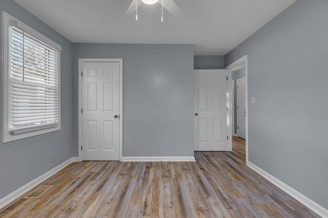 a view of a room with wooden floor and a window