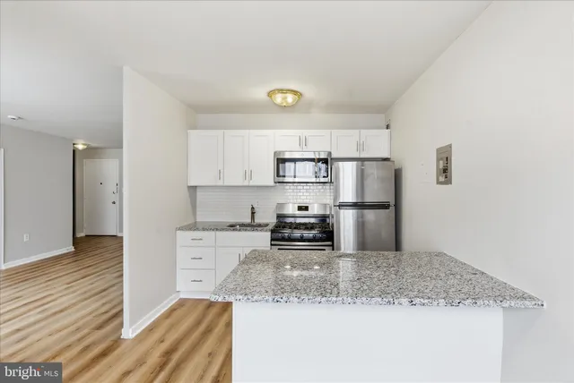 a kitchen with stainless steel appliances granite countertop a sink refrigerator and cabinets