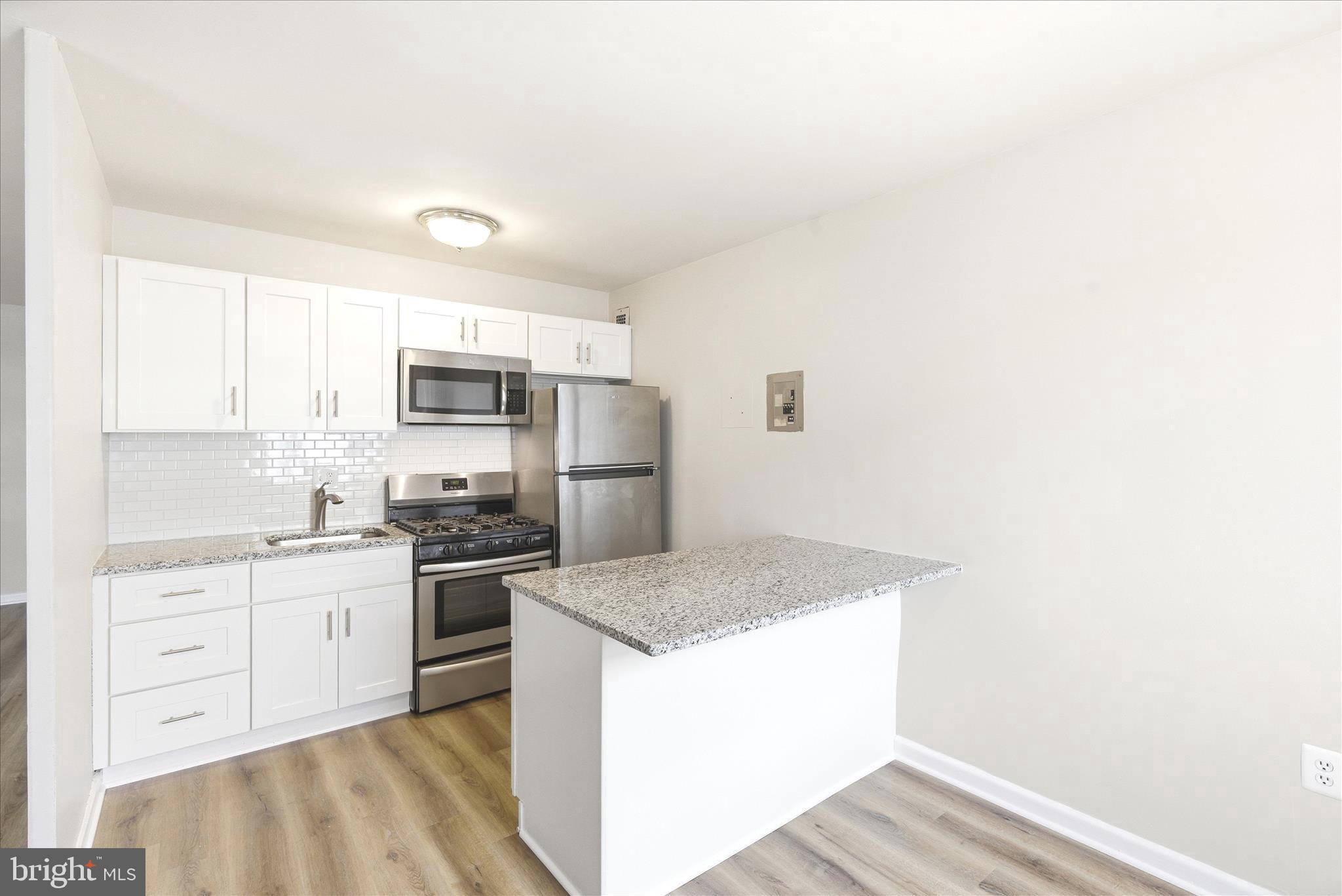 1200 South Arlington Ridge Road, Unit 717 Arlington, VA 22202 - Photo 2 of 24 a kitchen with granite countertop white cabinets and stainless steel appliances