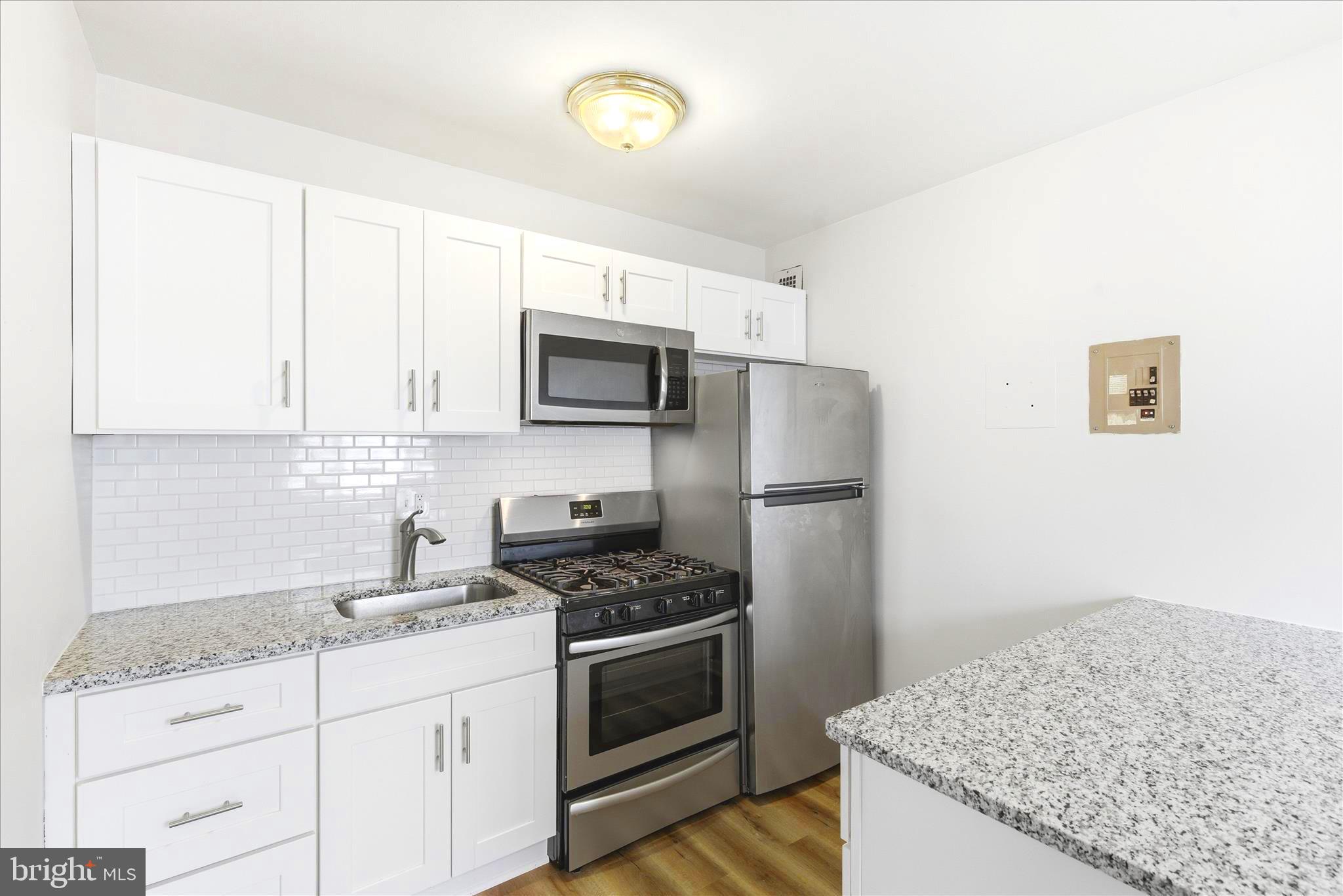 1200 South Arlington Ridge Road, Unit 717 Arlington, VA 22202 - Photo 4 of 24 a kitchen with granite countertop a sink stove and refrigerator