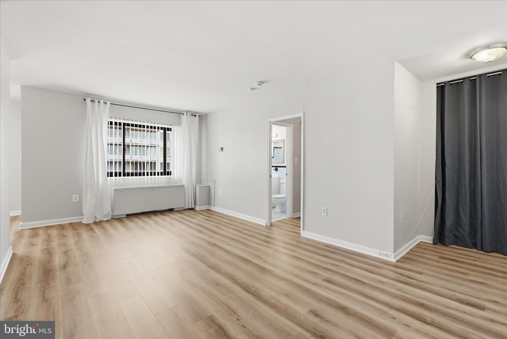 1200 South Arlington Ridge Road, Unit 717 Arlington, VA 22202 - Photo 5 of 24 a view of an empty room with wooden floor and a window