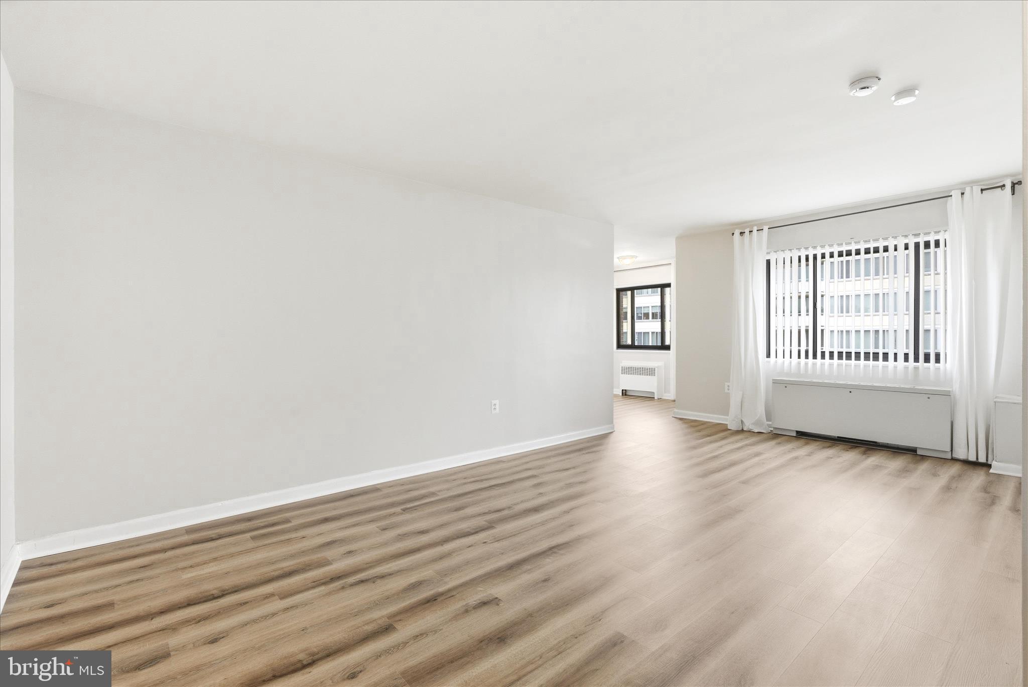 1200 South Arlington Ridge Road, Unit 717 Arlington, VA 22202 - Photo 6 of 24 an empty room with wooden floor and windows