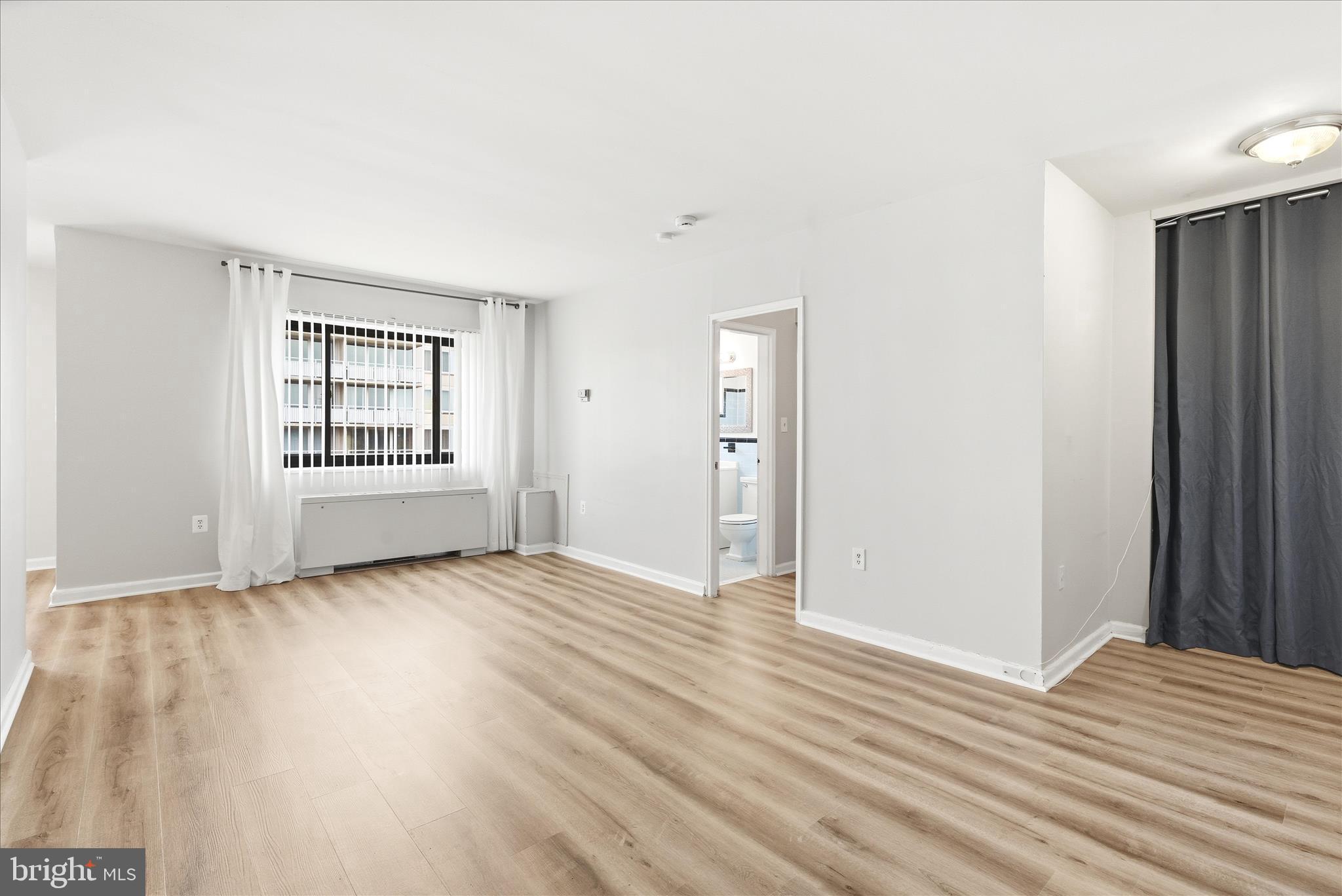 1200 South Arlington Ridge Road, Unit 717 Arlington, VA 22202 - Photo 7 of 24 a view of an empty room with wooden floor and a window