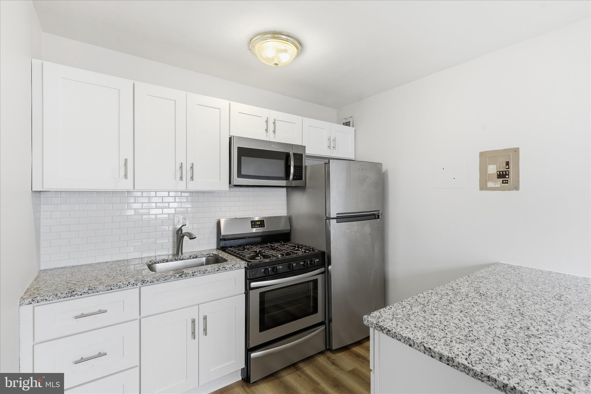1200 South Arlington Ridge Road, Unit 717 Arlington, VA 22202 - Photo 9 of 24 a kitchen with granite countertop a sink stove and refrigerator