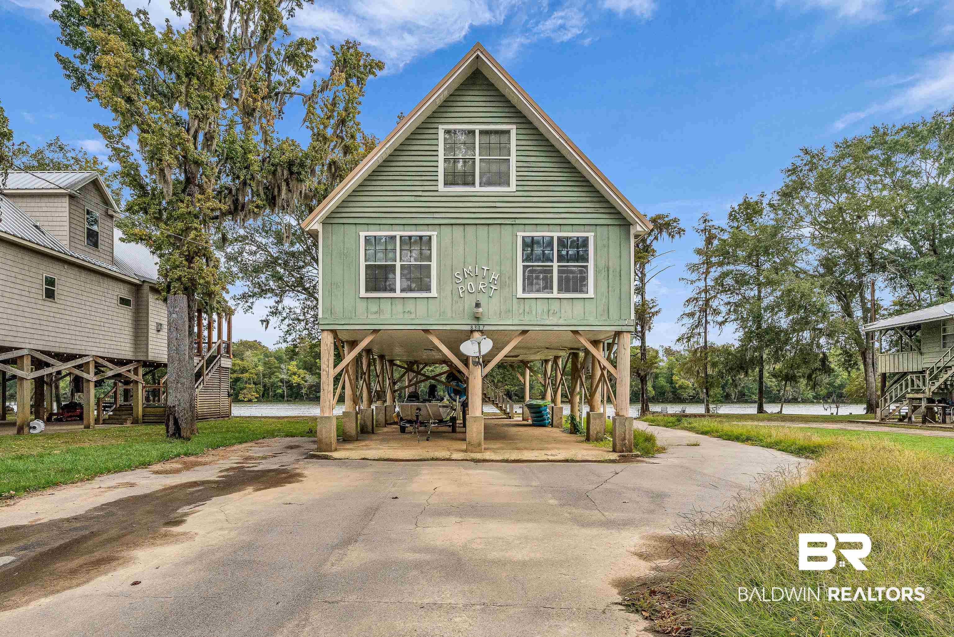 View of front of house with a carport, concrete driveway, and stairway