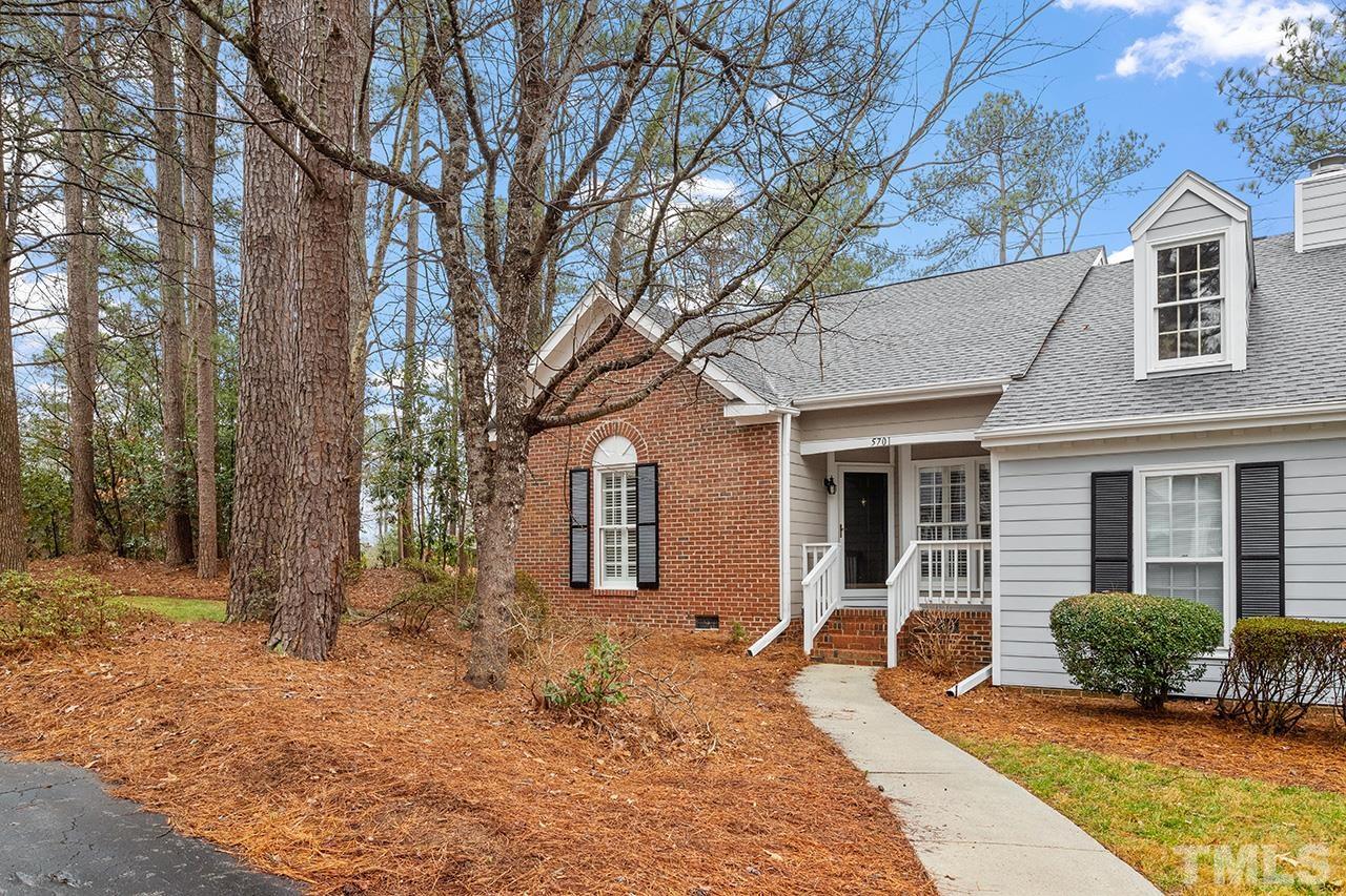 a front view of a house with a yard and potted plants