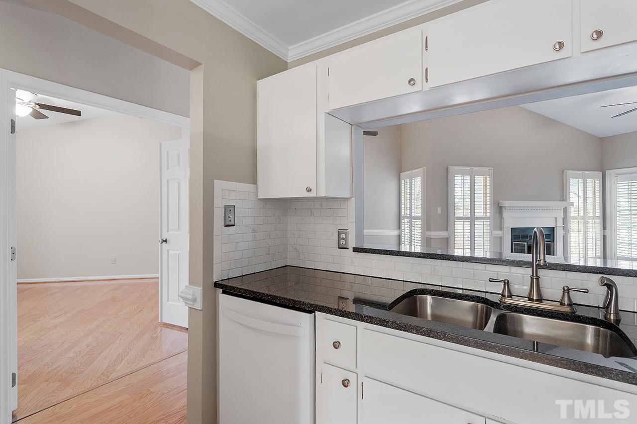 5701 Grasmere Court Raleigh, NC 27609 - Photo 12 of 34 a kitchen with granite countertop a sink and cabinets