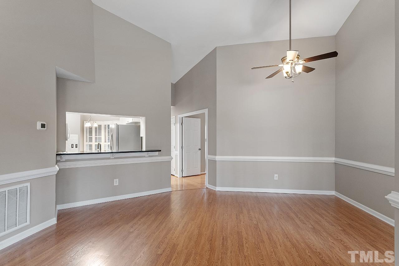 5701 Grasmere Court Raleigh, NC 27609 - Photo 22 of 34 a view of an empty room with wooden floor and a ceiling fan