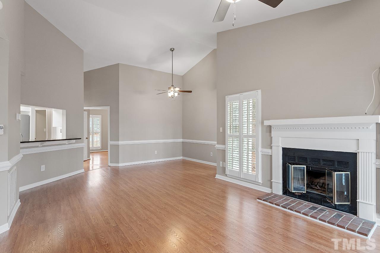 5701 Grasmere Court Raleigh, NC 27609 - Photo 25 of 34 an empty room with wooden floor fireplace cabinet and windows