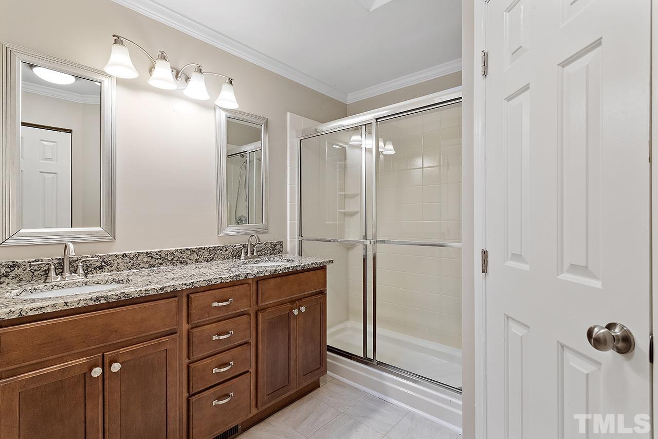 5701 Grasmere Court Raleigh, NC 27609 - Photo 32 of 34 a bathroom with a granite countertop sink mirror and a shower