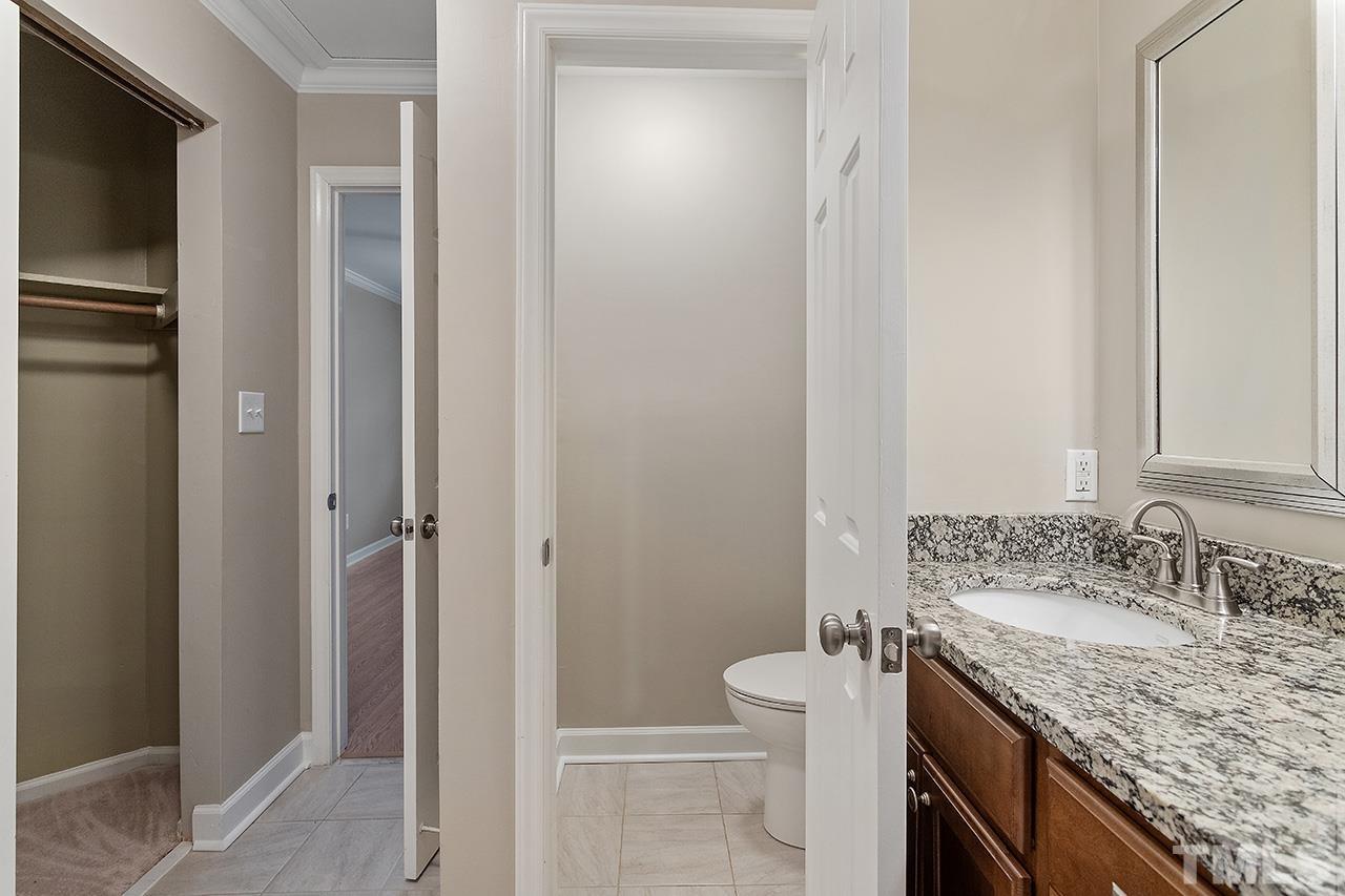 5701 Grasmere Court Raleigh, NC 27609 - Photo 33 of 34 a bathroom with a granite countertop sink and a mirror