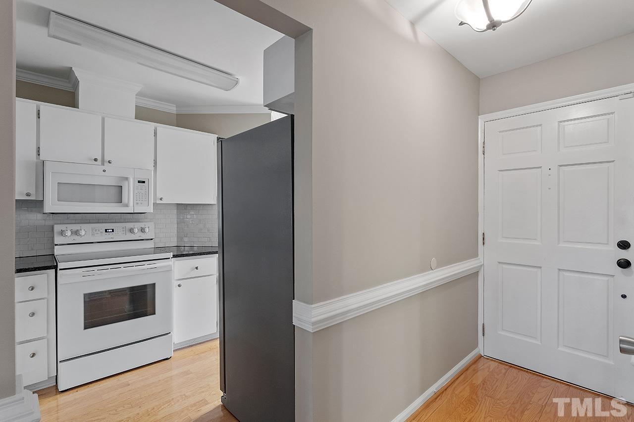 5701 Grasmere Court Raleigh, NC 27609 - Photo 8 of 34 a kitchen with white cabinets and white appliances