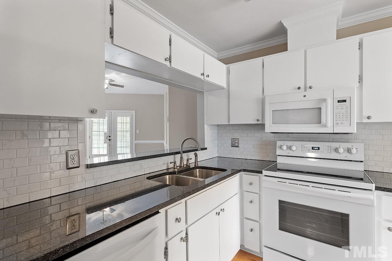 5701 Grasmere Court Raleigh, NC 27609 - Photo 9 of 34 a kitchen with appliances cabinets and a sink