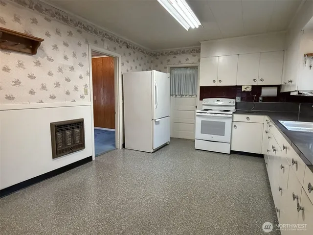 a kitchen with stainless steel appliances a stove a refrigerator and white cabinets