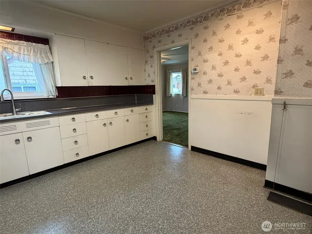 a kitchen with granite countertop white cabinets sink and dishwasher