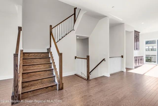 a view of staircase with wooden floor and white walls