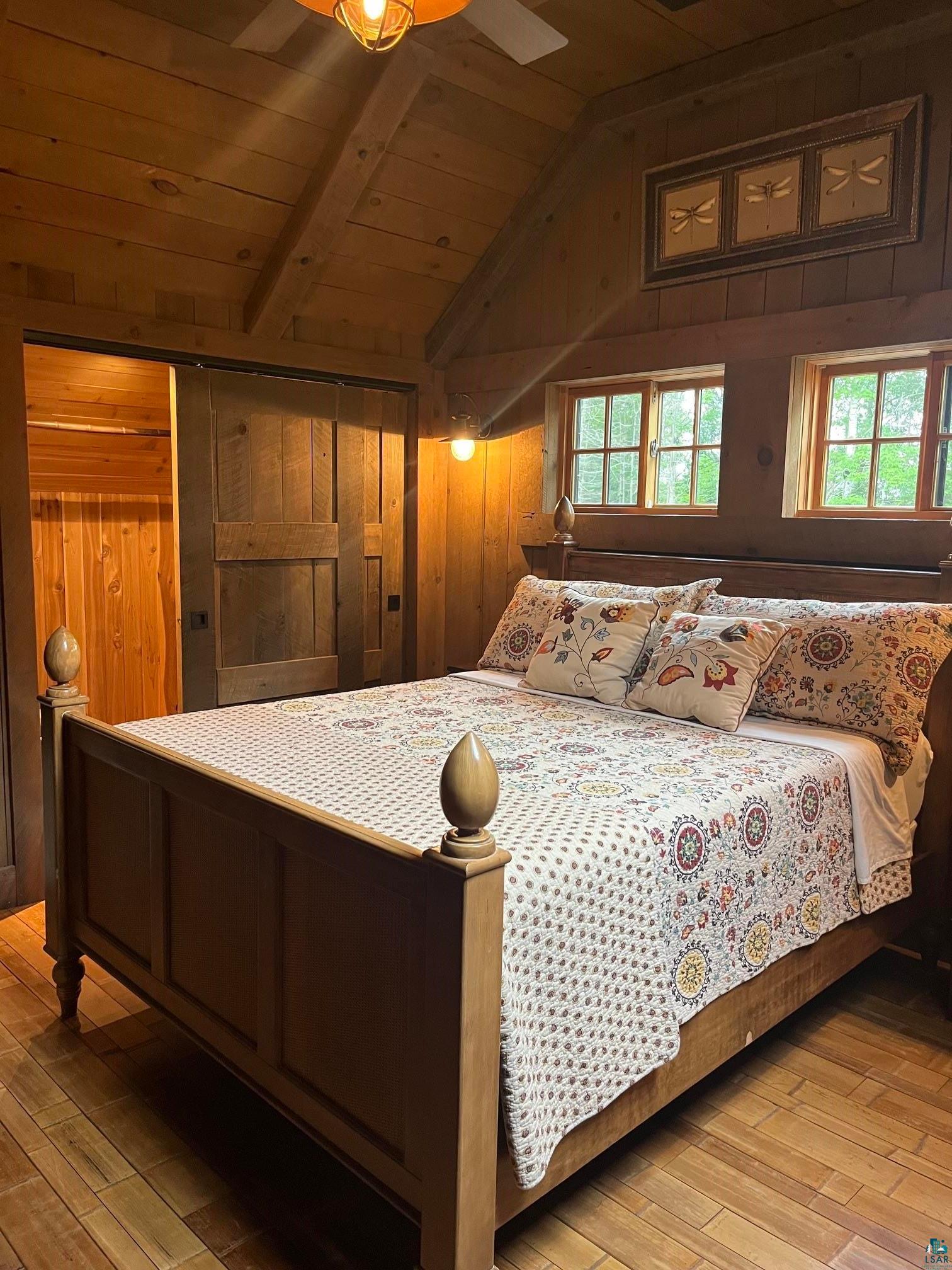 70745 Range Line Road Iron River, WI 54847 - Photo 22 of 40 Wood paneling, wood-finish flooring, exposed beam ceiling, two pane windows, wood door