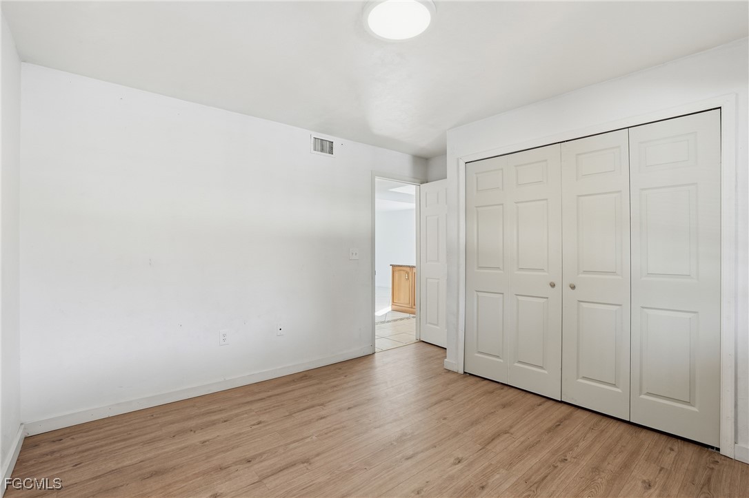240 Pebble Beach Boulevard, Unit 712 Naples, FL 34113 - Photo 13 of 22 a view of an empty room with wooden floor