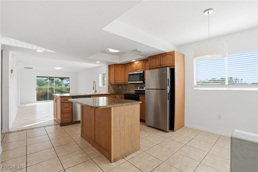 240 Pebble Beach Boulevard, Unit 712 Naples, FL 34113 - Photo 9 of 22 a kitchen with stainless steel appliances granite countertop a refrigerator oven a s sink and dishwasher