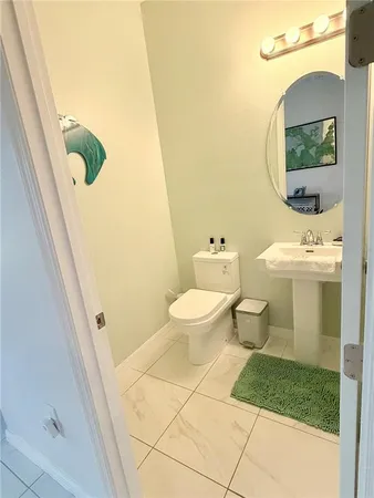 a bathroom with a toilet a sink and a mirror