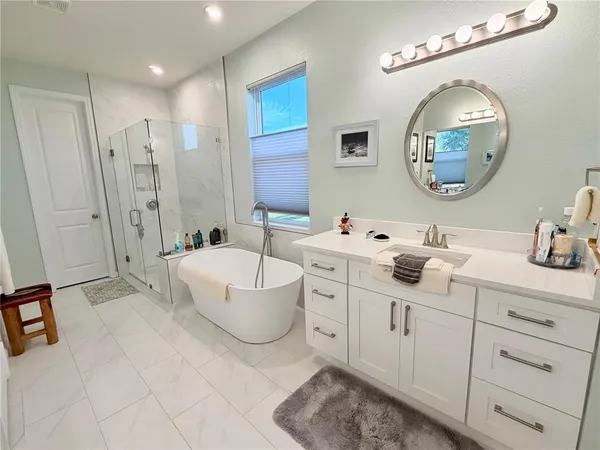 a spacious bathroom with a double vanity sink mirror and bathtub
