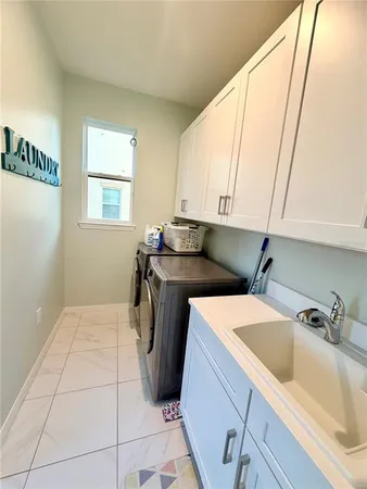 a utility room with a sink washer and dryer