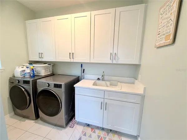 a utility room with sink dryer and washer