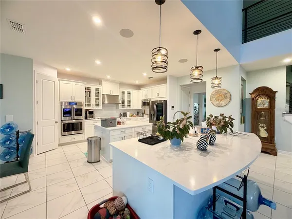 a kitchen with stainless steel appliances kitchen island granite countertop a sink cabinets and living room view