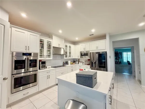 a kitchen with a sink a counter top space stainless steel appliances and cabinets