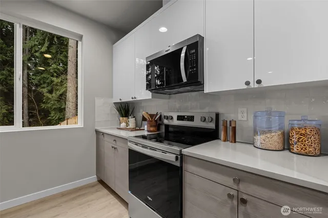 a kitchen with a stove and a white cabinets