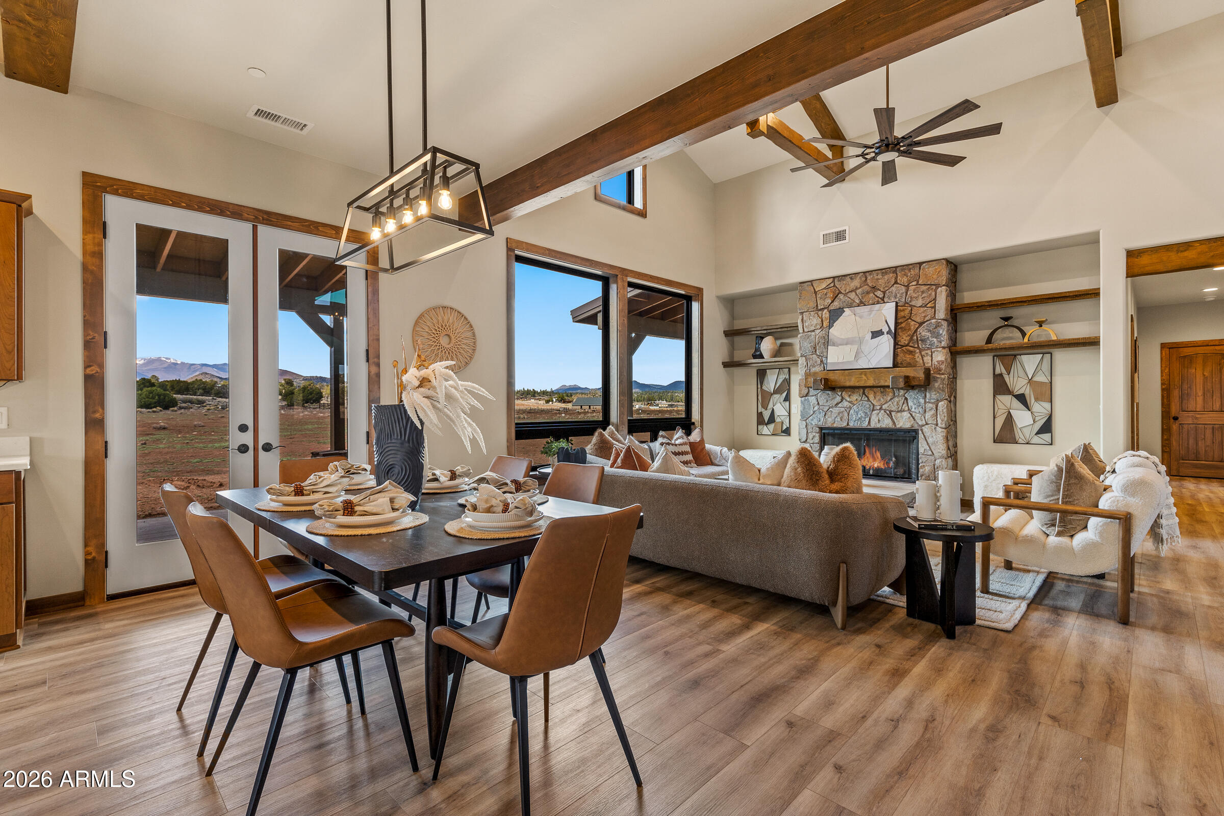 6570 Meadows Lane Flagstaff, AZ 86004 - Photo 12 of 66 a dining room with wooden floor a chandelier fan a wooden table and chairs