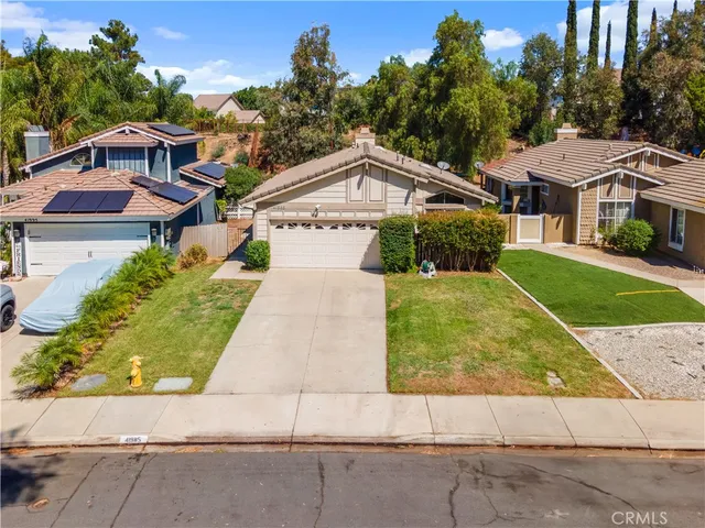 a aerial view of a house with a yard and potted plants