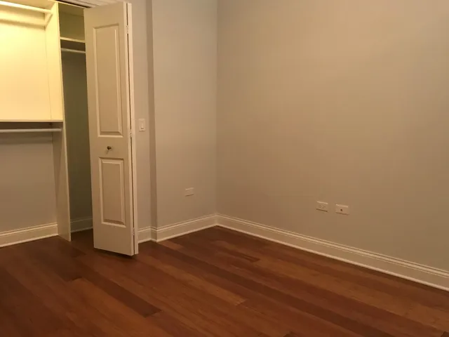 a view of a small space with wooden floor and a window