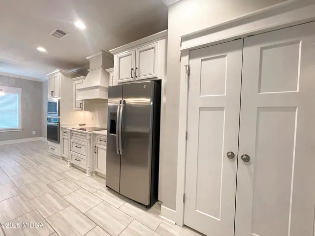 a kitchen with stainless steel appliances a refrigerator sink and cabinets