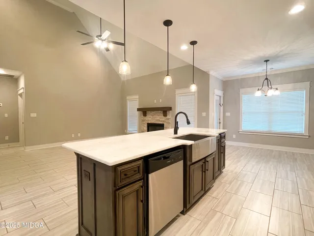 a kitchen with a sink a chandelier and a wooden floor