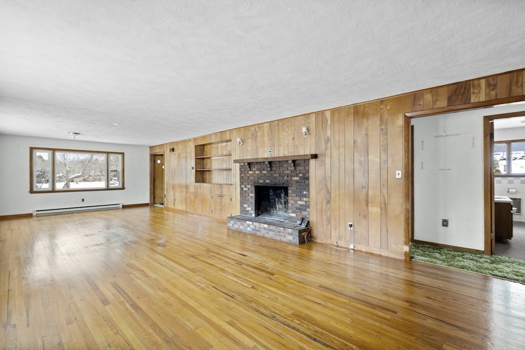 44 Sumner Street Gloucester, MA 01930 - Photo 7 of 40 a view of a livingroom with wooden floor and a fireplace