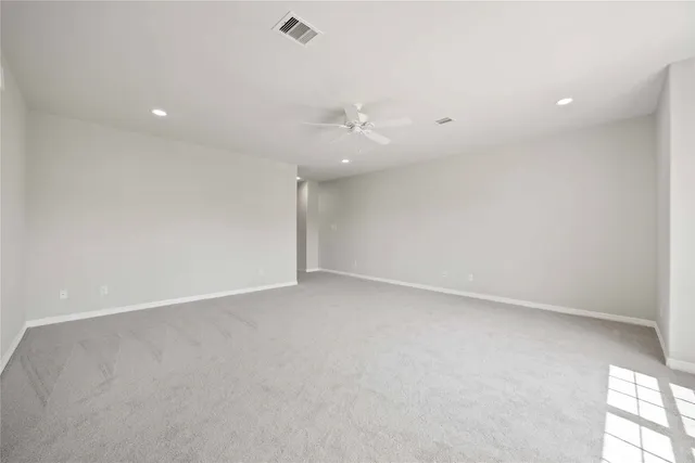 an empty room with an entryway and fan