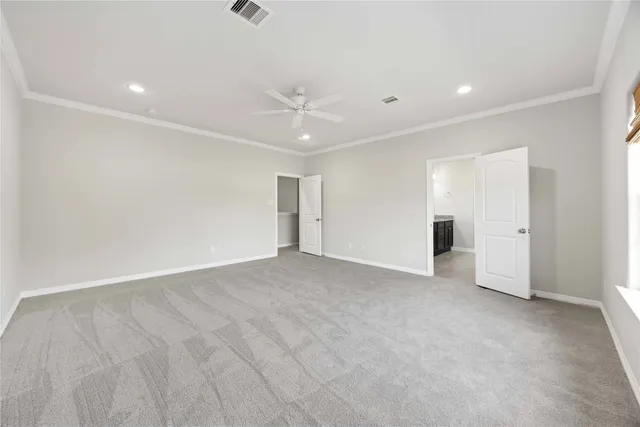 an empty room with an entryway and chandelier fan