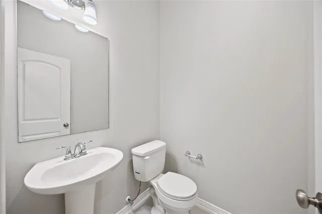 a bathroom with a toilet a sink and mirror
