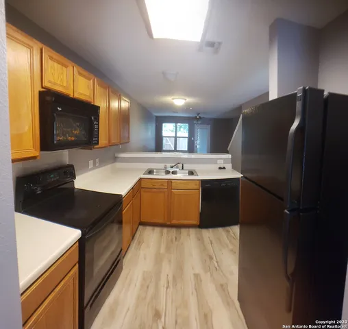 a large kitchen with a sink a microwave and cabinets