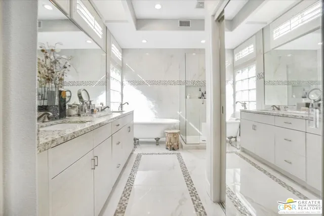 a spacious bathroom with a granite countertop sink mirror and a bath tub