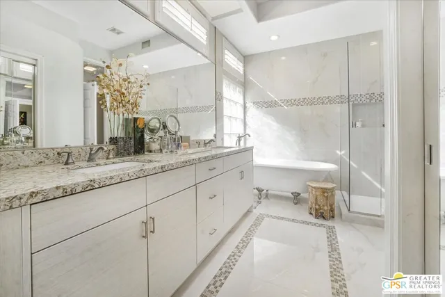 a bathroom with a granite countertop sink mirror and a bathtub