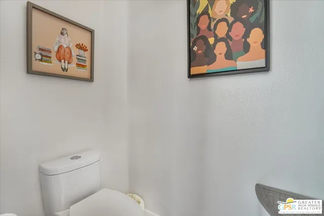 a white toilet sitting next to a white wall