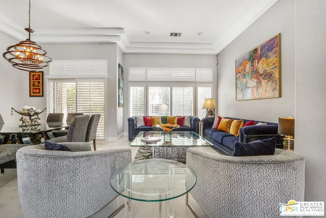 a living room with fireplace furniture and a chandelier