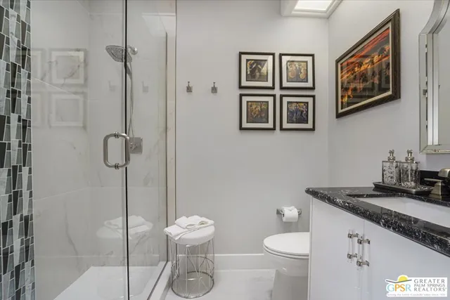a bathroom with a granite countertop toilet and a sink
