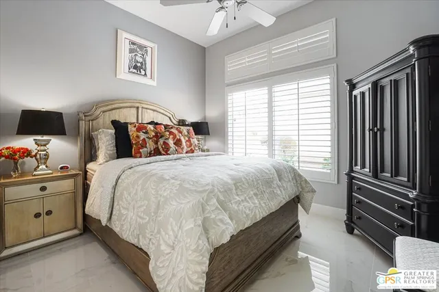 a bed sitting in a bedroom next to a window with a chandelier