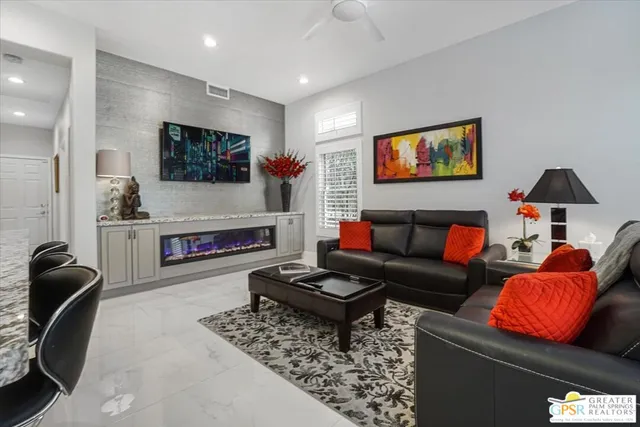a living room with furniture a flat screen tv and a fireplace